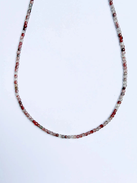 Andesine Beaded Necklace with red and white beads on a light gray background