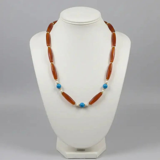 Necklace with brown beads and blue accents on a white mannequin bust against a gray background