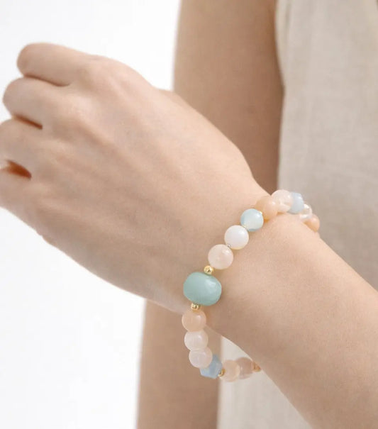 Bracelet with pastel-colored beads on a wrist against a neutral background