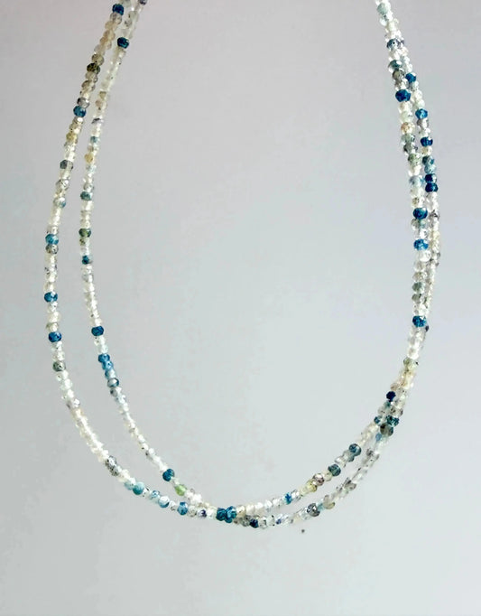 blue and clear quartz micro-faceted japanese minimalist jewelry on a grey background