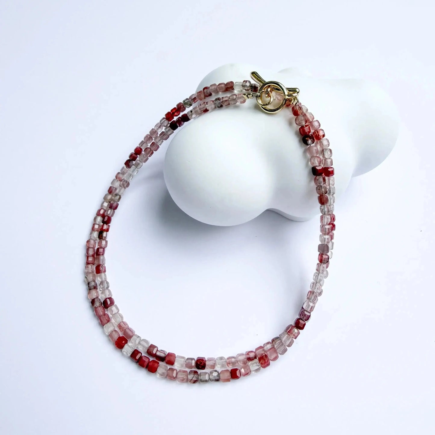 Andesine Beaded bracelet with gold clasp on a white surface