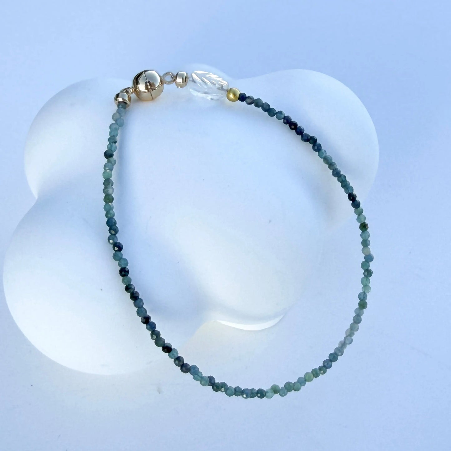 Bracelet with blue tourmaline beads on a white background