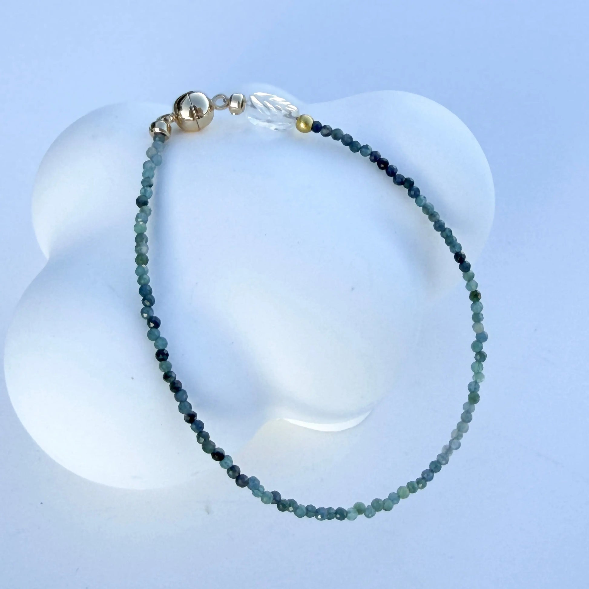 Bracelet with blue tourmaline beads on a white background