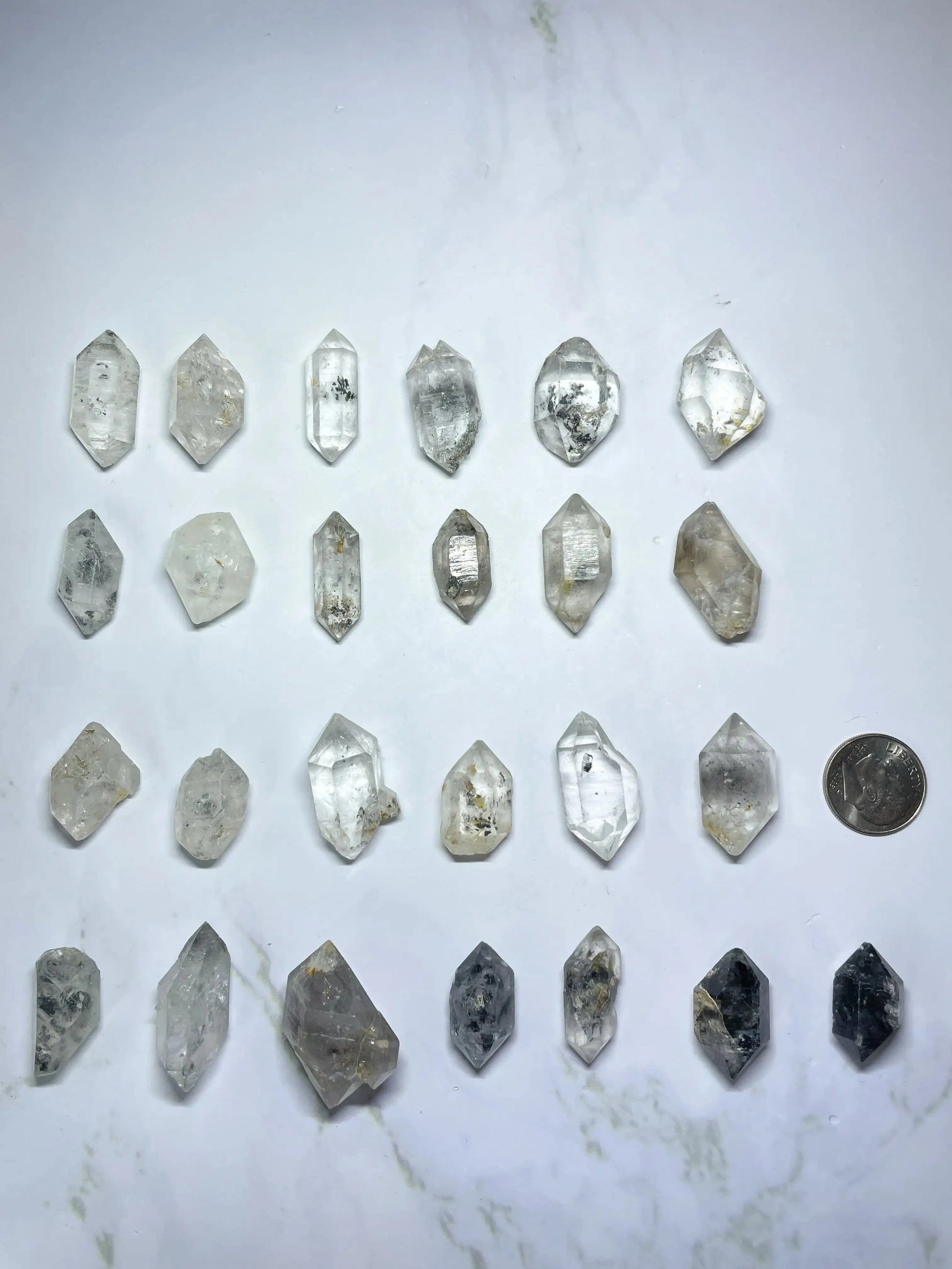 Collection of DT crystal or mineral specimens on a marble surface