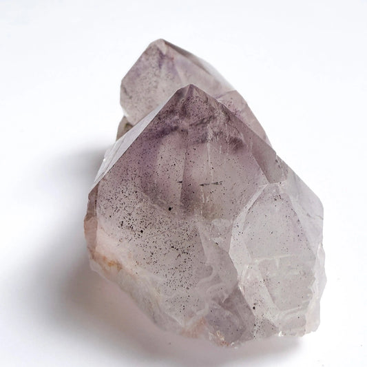 Amethyst Crystal with black hematite inclusion on a white background