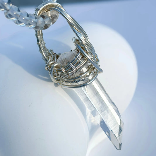 Crystal pendant with silver chain on a white background
