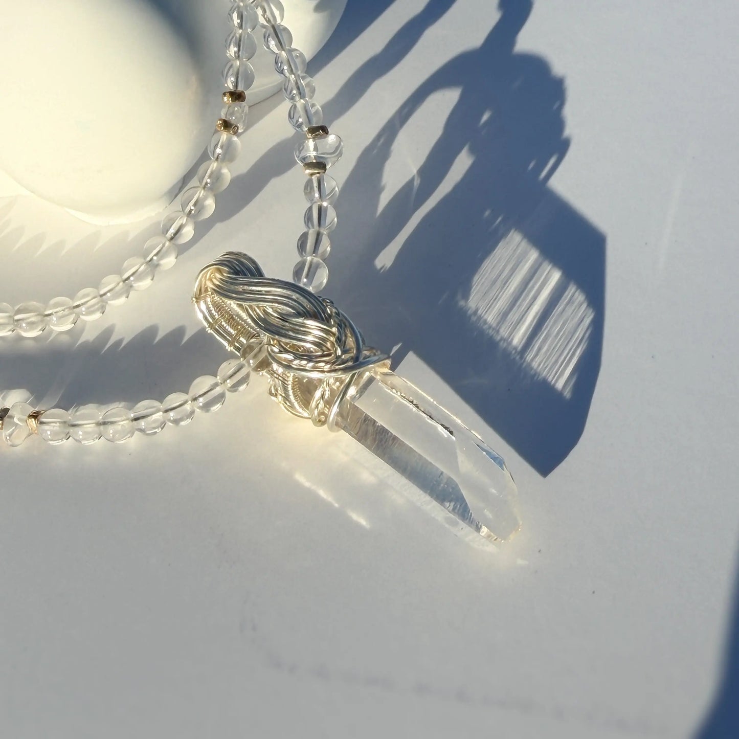 Necklace with a clear crystal pendant on a light background