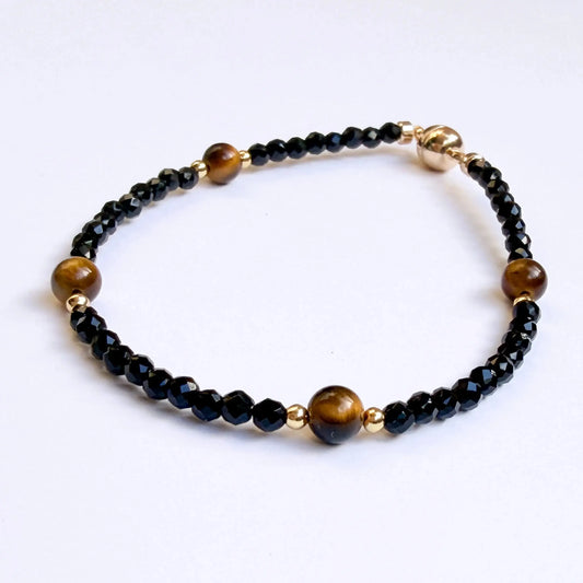 Beaded bracelet with black and gold beads on a white background