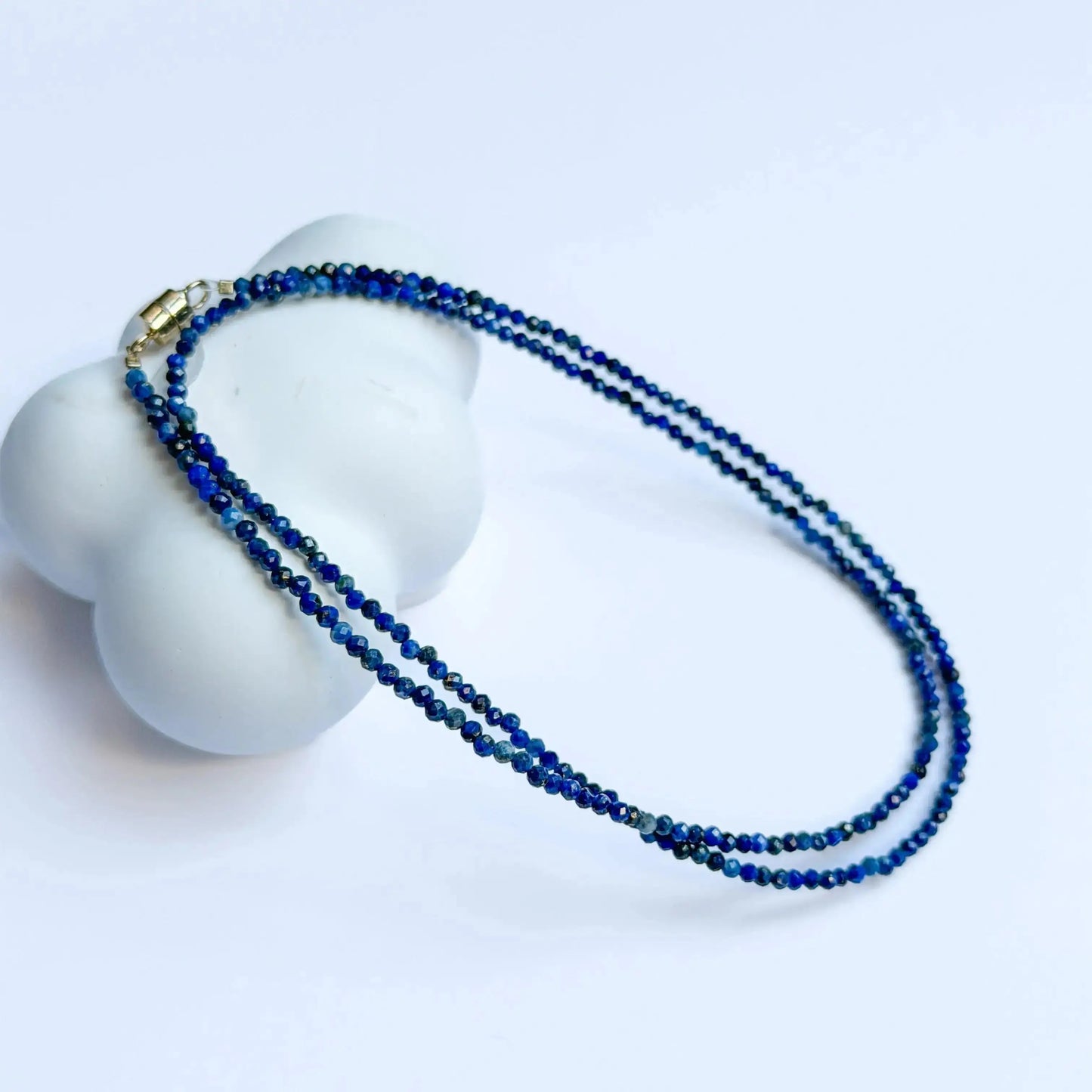 Lapis Lazuli Jewelry - Blue beaded necklace on a white mannequin bust with a light blue background