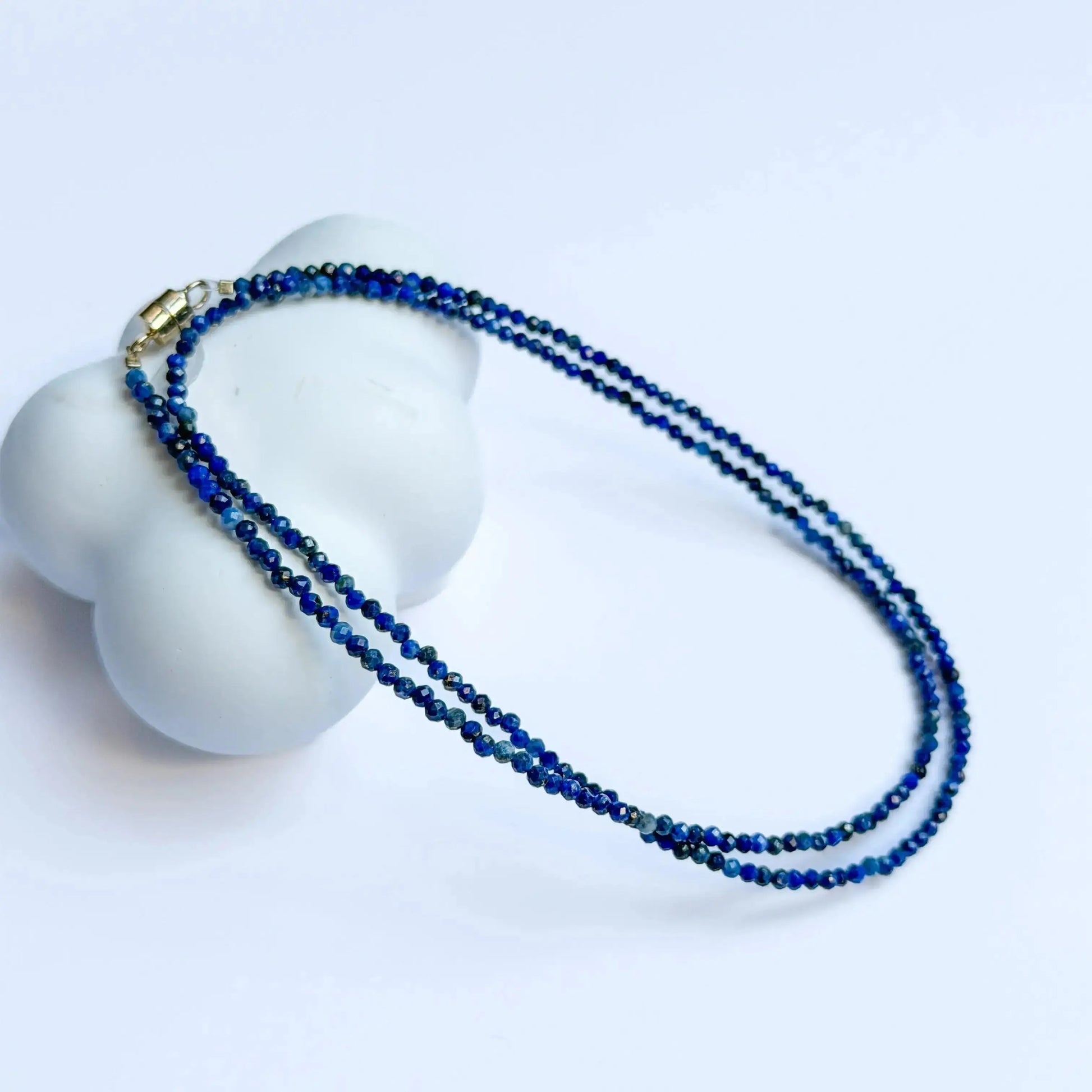 Lapis Lazuli Jewelry - Blue beaded necklace on a white mannequin bust with a light blue background