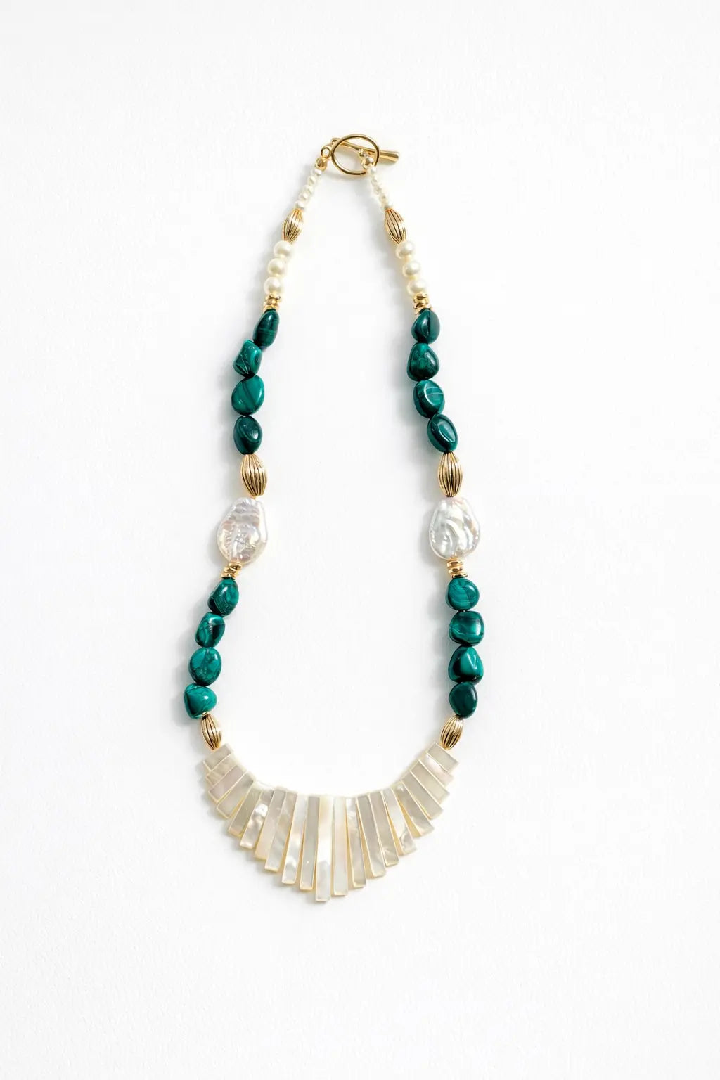 Necklace with green beads and gold accents on a white background