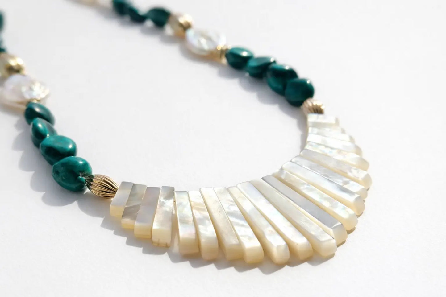 Necklace with green and white beads on a white background