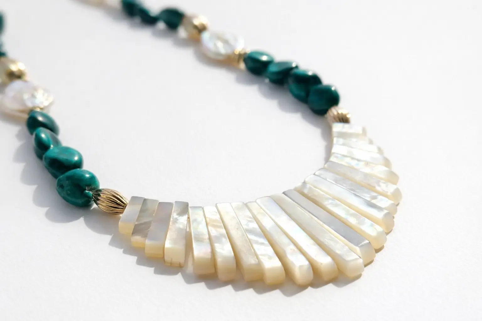 Necklace with green and white beads on a white background