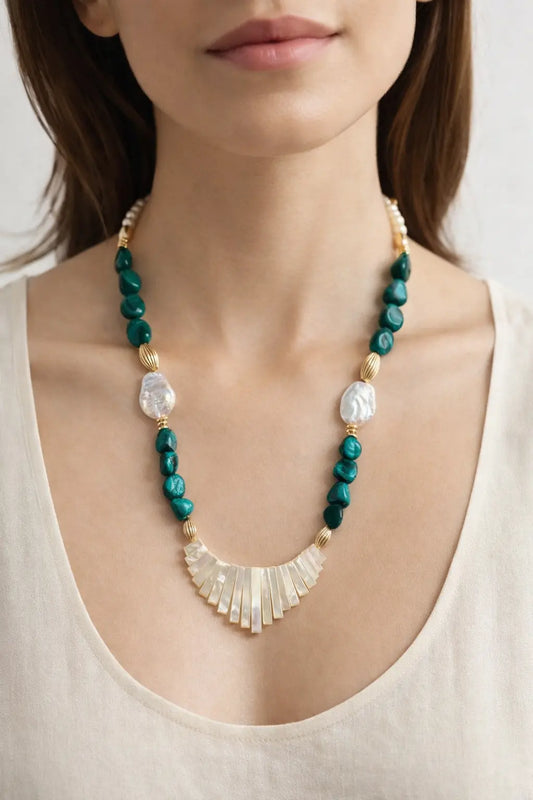 Necklace with green beads and a gold accent worn by a person