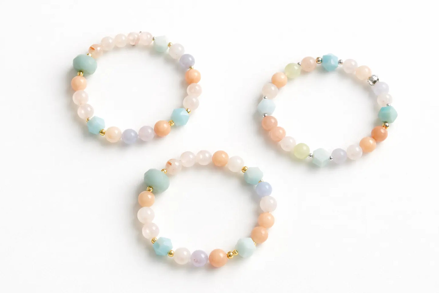 Three beaded bracelets with pastel colors on a white background