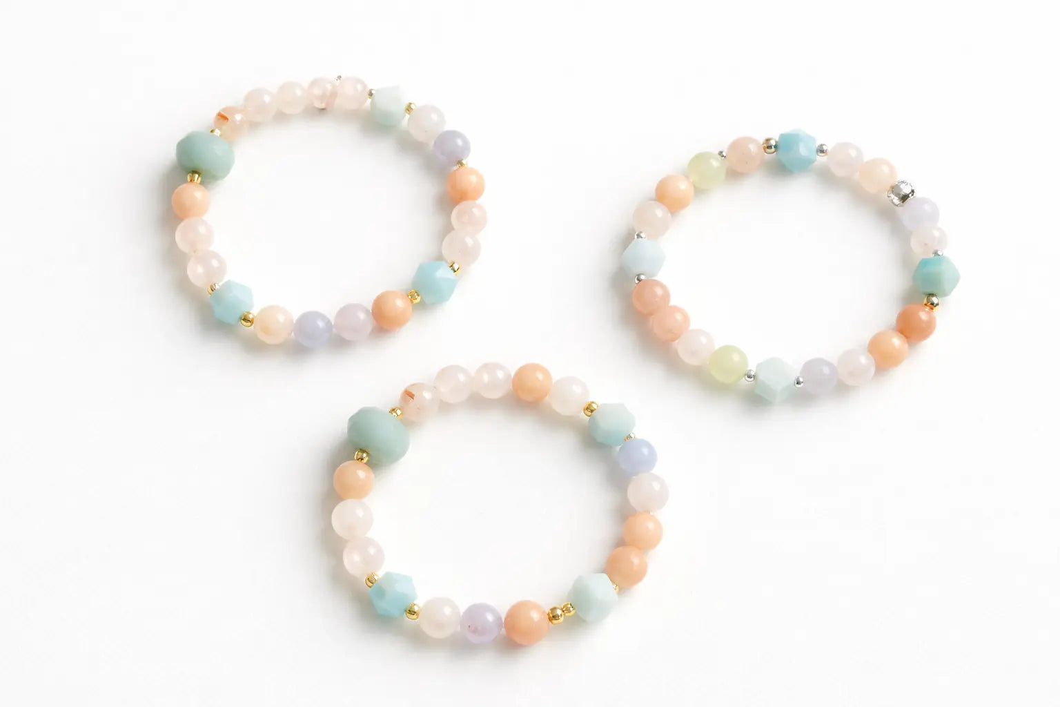 Three beaded bracelets with pastel colors on a white background
