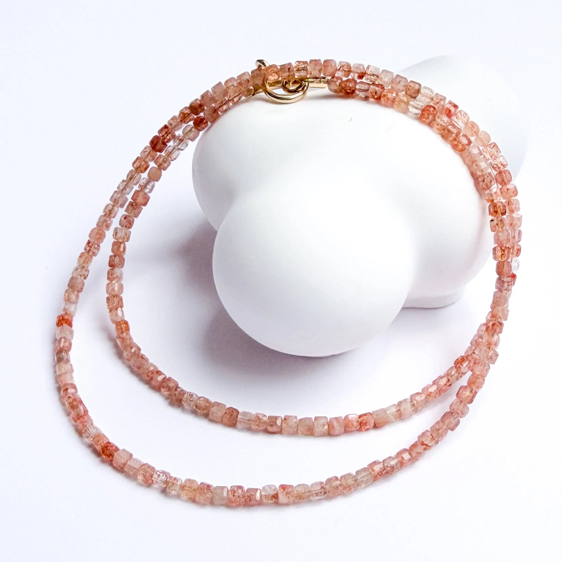 sunstone Necklace with orange beads on a white background