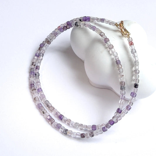 Super Seven Amethyst Beaded necklace on a mannequin head with a white background