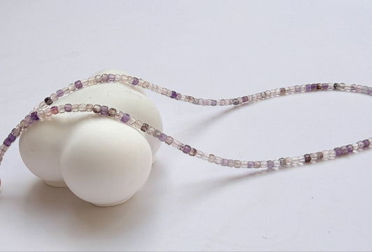 Super 7 Amethyst Necklace with purple and clear beads on a white background