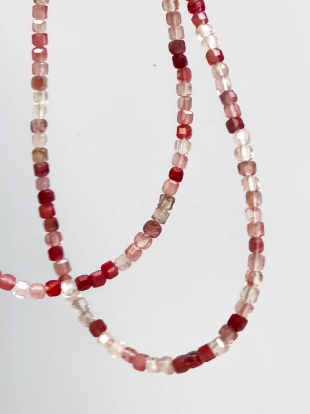 Andesine Japanese Minimalist Gemstone Jewelry with sparkly red color in motion